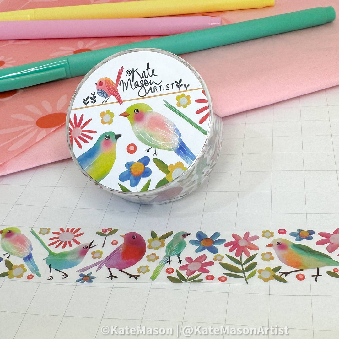 Roll of washi tape with colorful bird design on a grid background