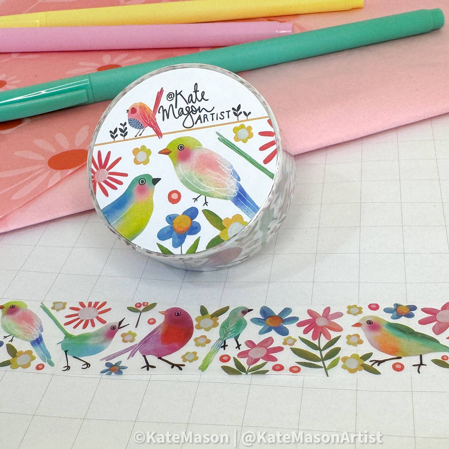 Roll of washi tape with colorful bird design on a grid background