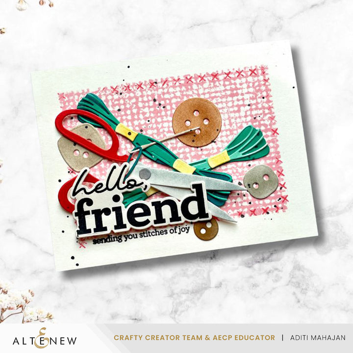 Greeting card with sewing-themed decorations and 'hello friend' text on a white marble background.