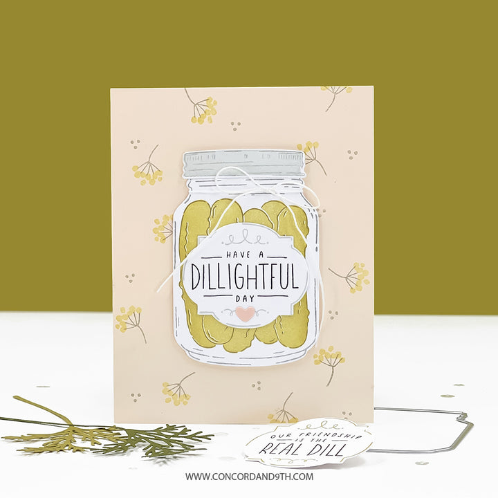 Card with a jar of pickles and text 'Have a Dillightful Day' on a beige background with dill illustrations.