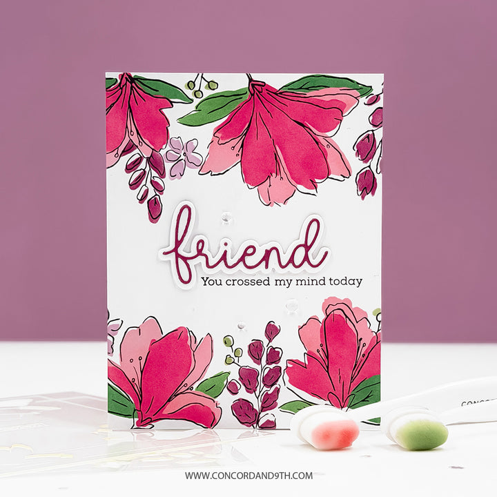 Greeting card with floral design and 'friend' text on a white surface with a purple background