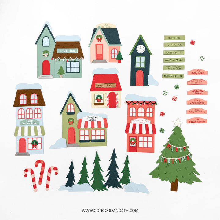 Concord & 9th North Pole Greetings Dies — village shop-front die-cuts labelled "Icicle Inn," "Cocoa & Co.," "Snowflake Sweets," "Tiny Treasures" and others, with candy canes, trees and shop-name sentiment strips.