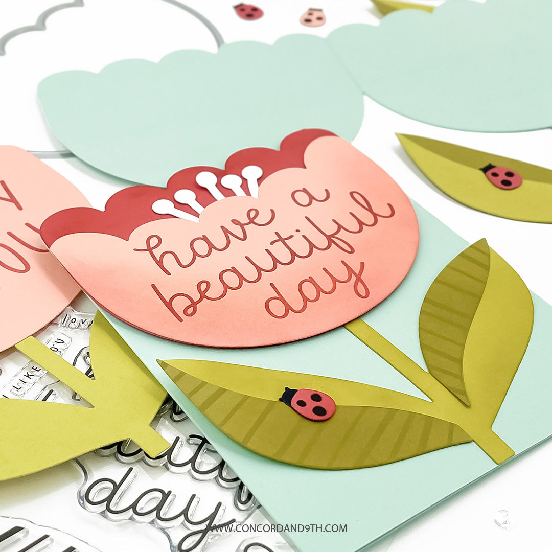 Card with flower and leaf-shaped cutout and 'have a beautiful day' text, surrounded by decorative elements.