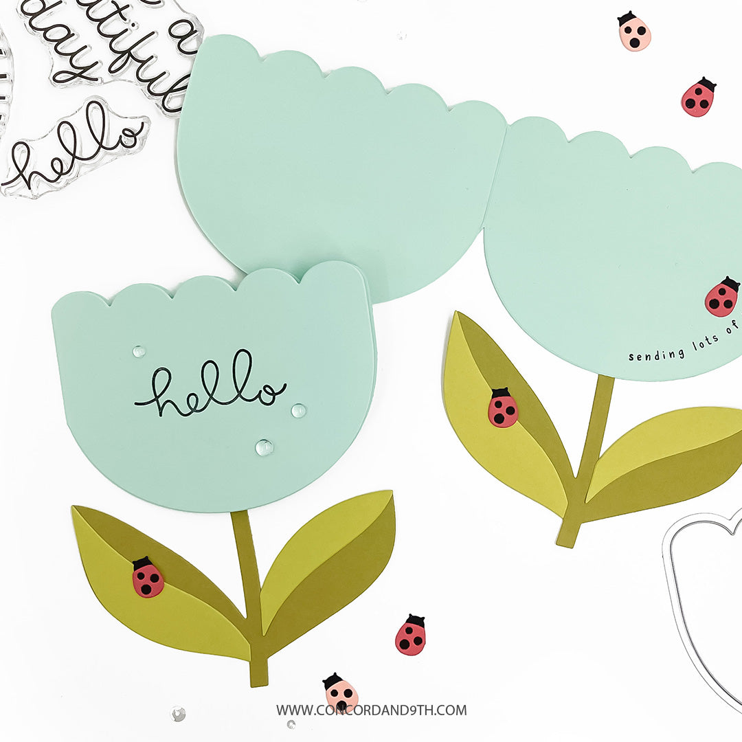 Decorative paper cutout of a flower with 'hello' text and ladybug illustrations on a white background.