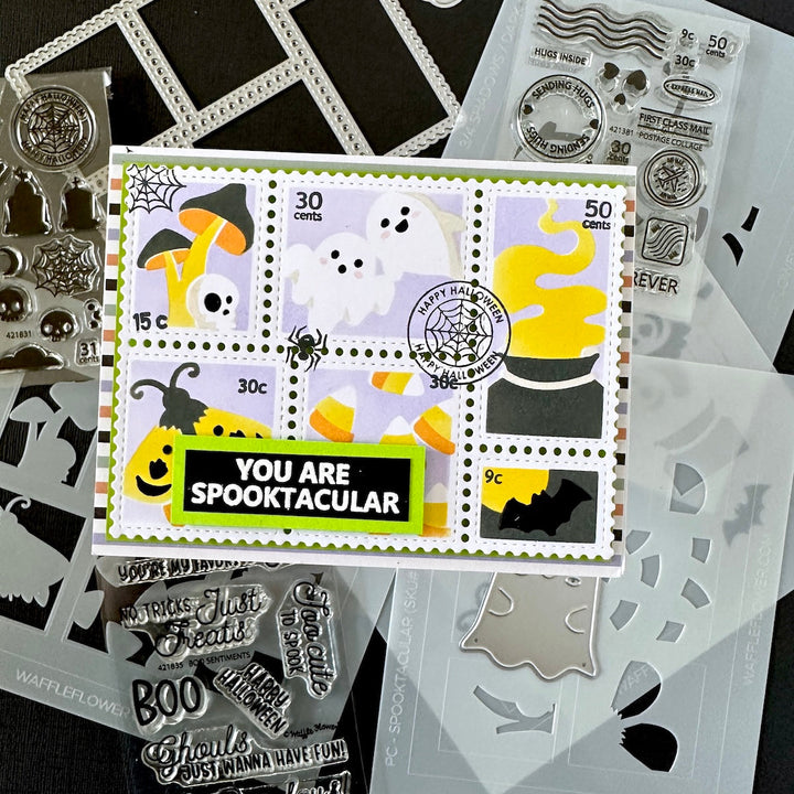 A Halloween-themed stamp set displayed on a dark background, featuring a central handmade greeting card with postage-stamp style graphics, plus surrounding clear and silver stamp sheets, dies, and embellishments.