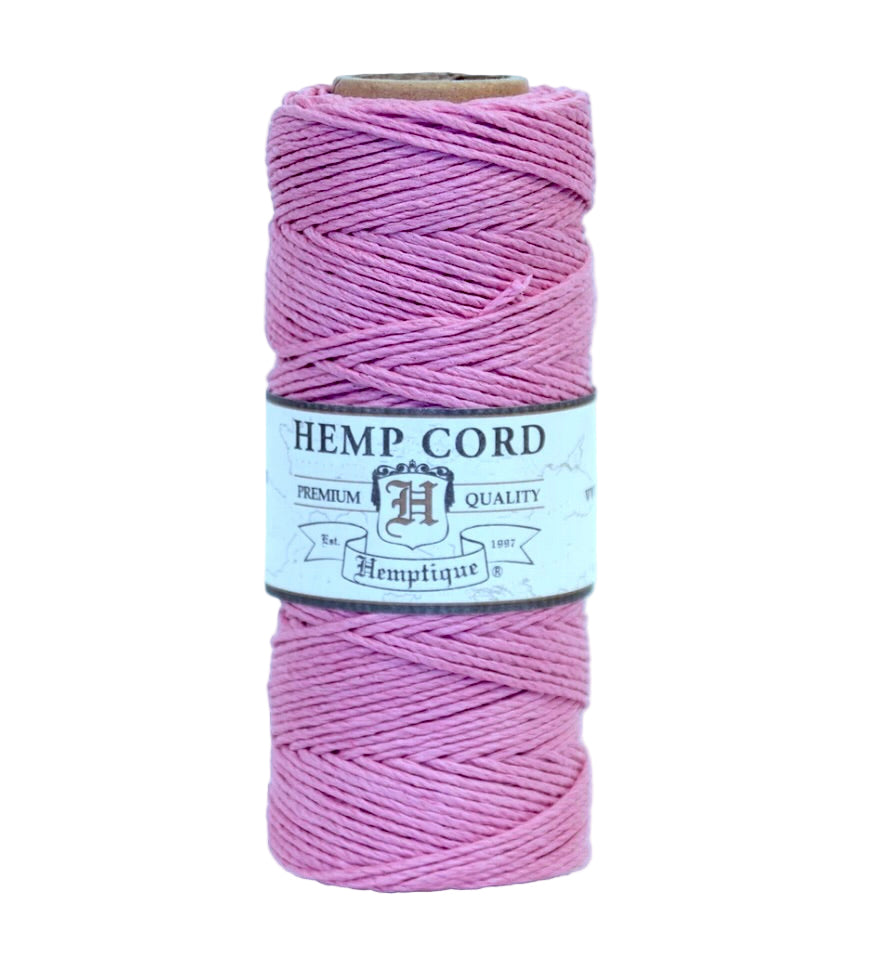 Spool of pink hemp cord with a label on a white background
