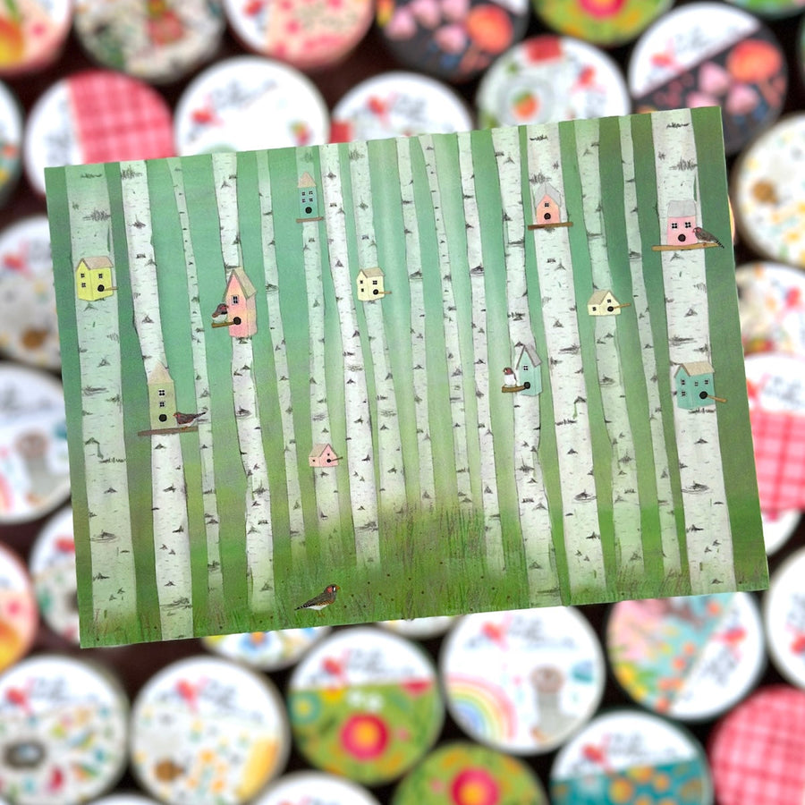 Note card with a forest design featuring trees and small houses on a green background, surrounded by colorful washi tapes