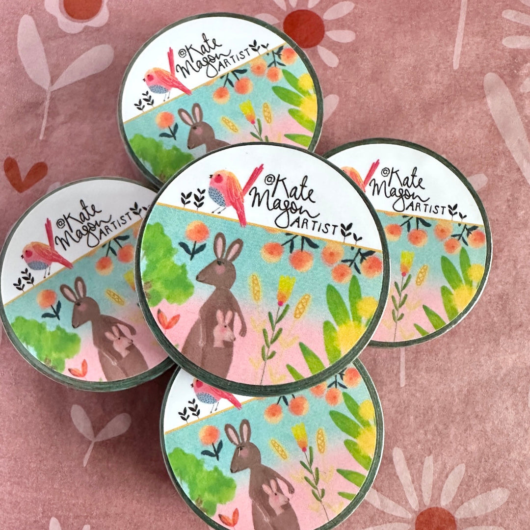 washi tape stack with floral and animal designs on a pink floral patterned background