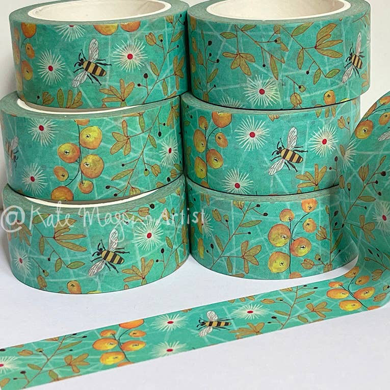 Rolls of aqua decorative tape with floral and bee pattern on a white background