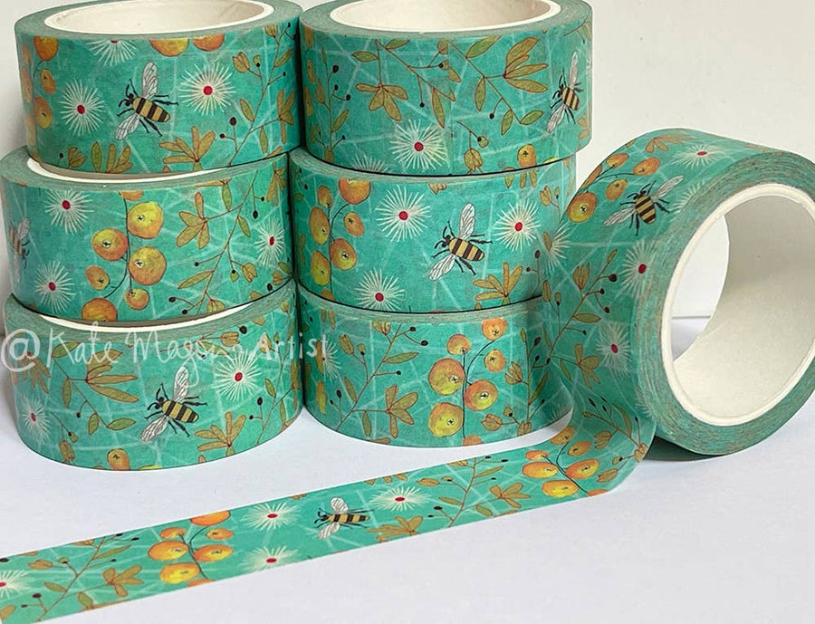 Rolls of aqua decorative tape with floral and bee pattern on a white background