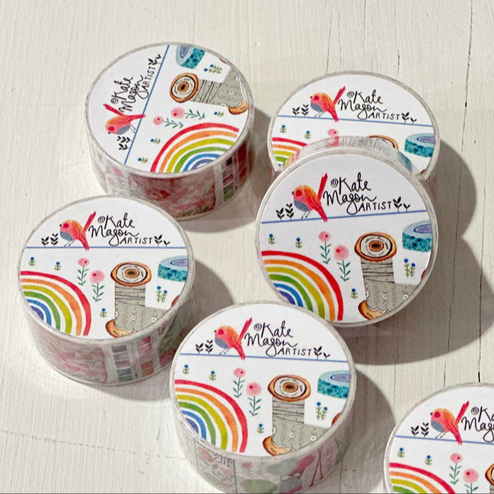 Set of six rolls of decorative tape with colorful designs on a light wooden surface.