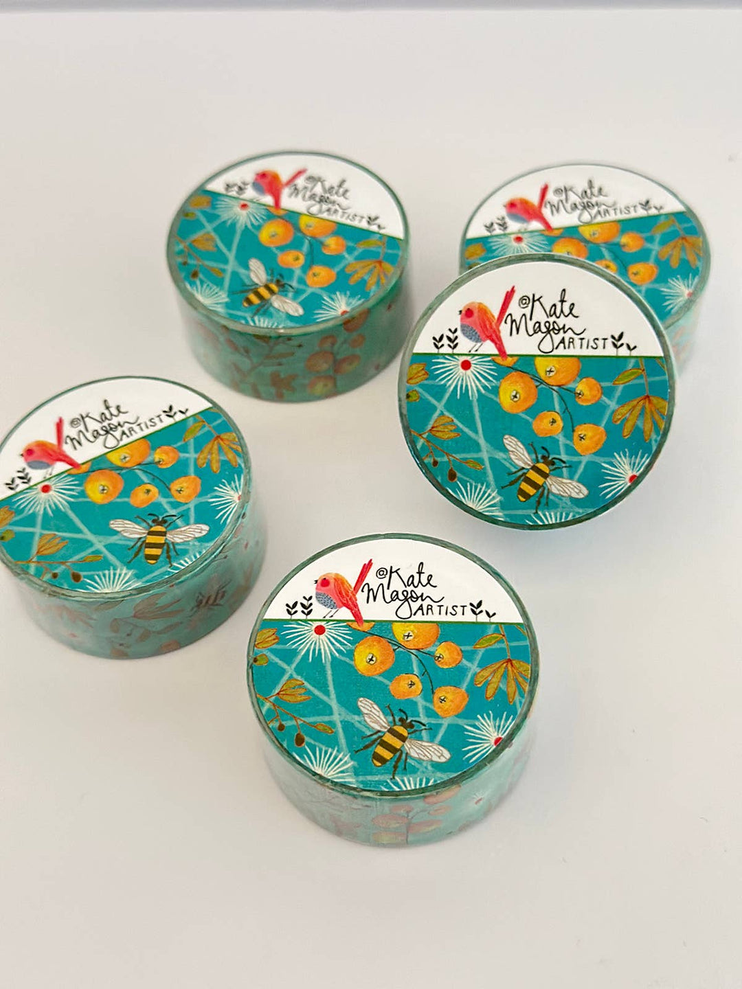 Five washi tapes decorative packaging floral and bee designs on a white background. 