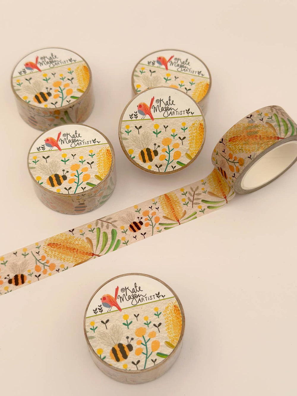 Set of washi tape rolls with floral and bee designs on a white background