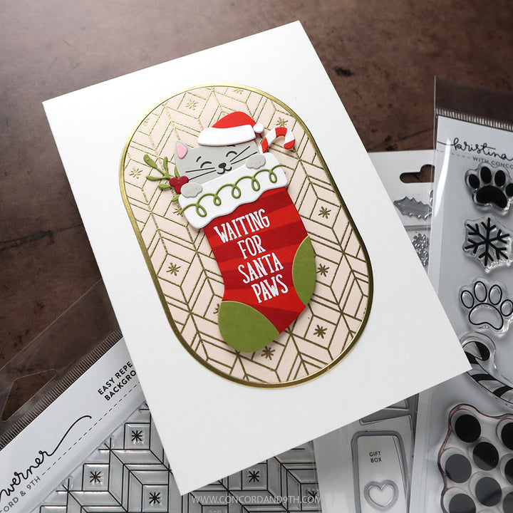 A card made with Kristina Werner's Happy Pawlidays Dies: a grey kitten in a Santa hat peeks out of a red stocking that says 'Waiting for Santa Paws'.