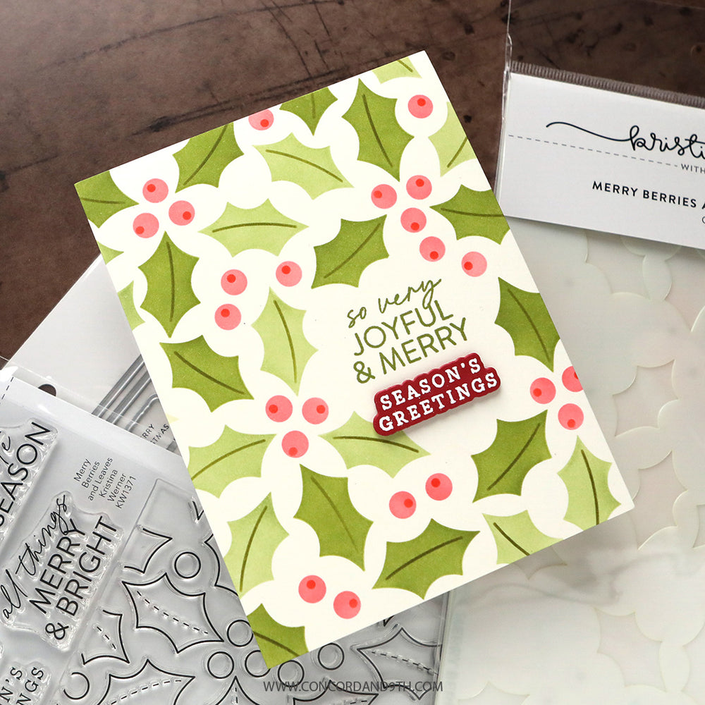 A card made with Kristina Werner's Merry Berries and Leaves Stencil Pack: a green holly and pink berry pattern with 'so very joyful & merry' and 'Season's Greetings'.