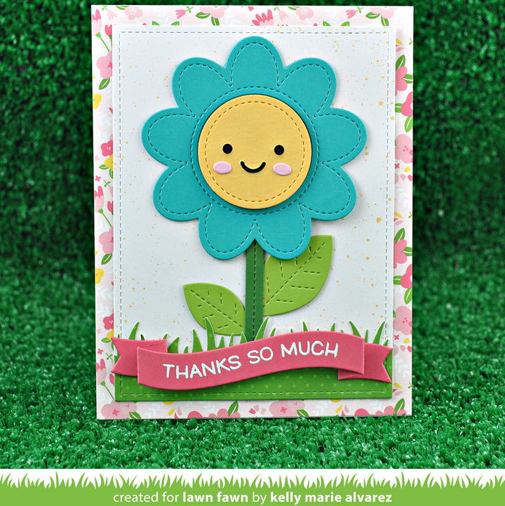 Card with a smiling flower design and 'Thanks so much' banner on a grassy background