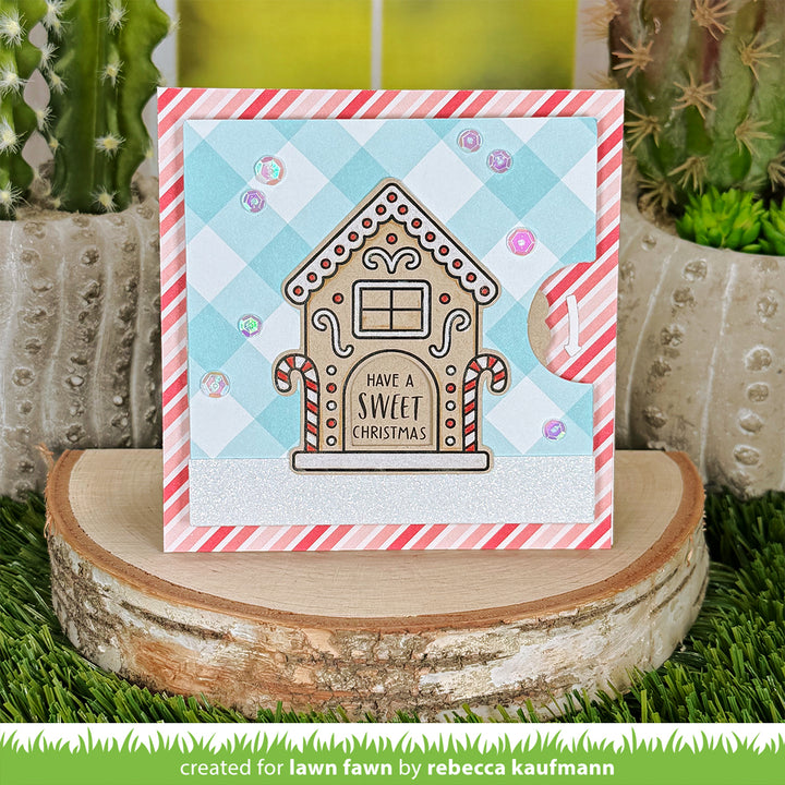 Lawn Fawn Gingerbread House card on a plaid background with a Have A Sweet Christmas door sentiment, by Rebecca Kaufmann