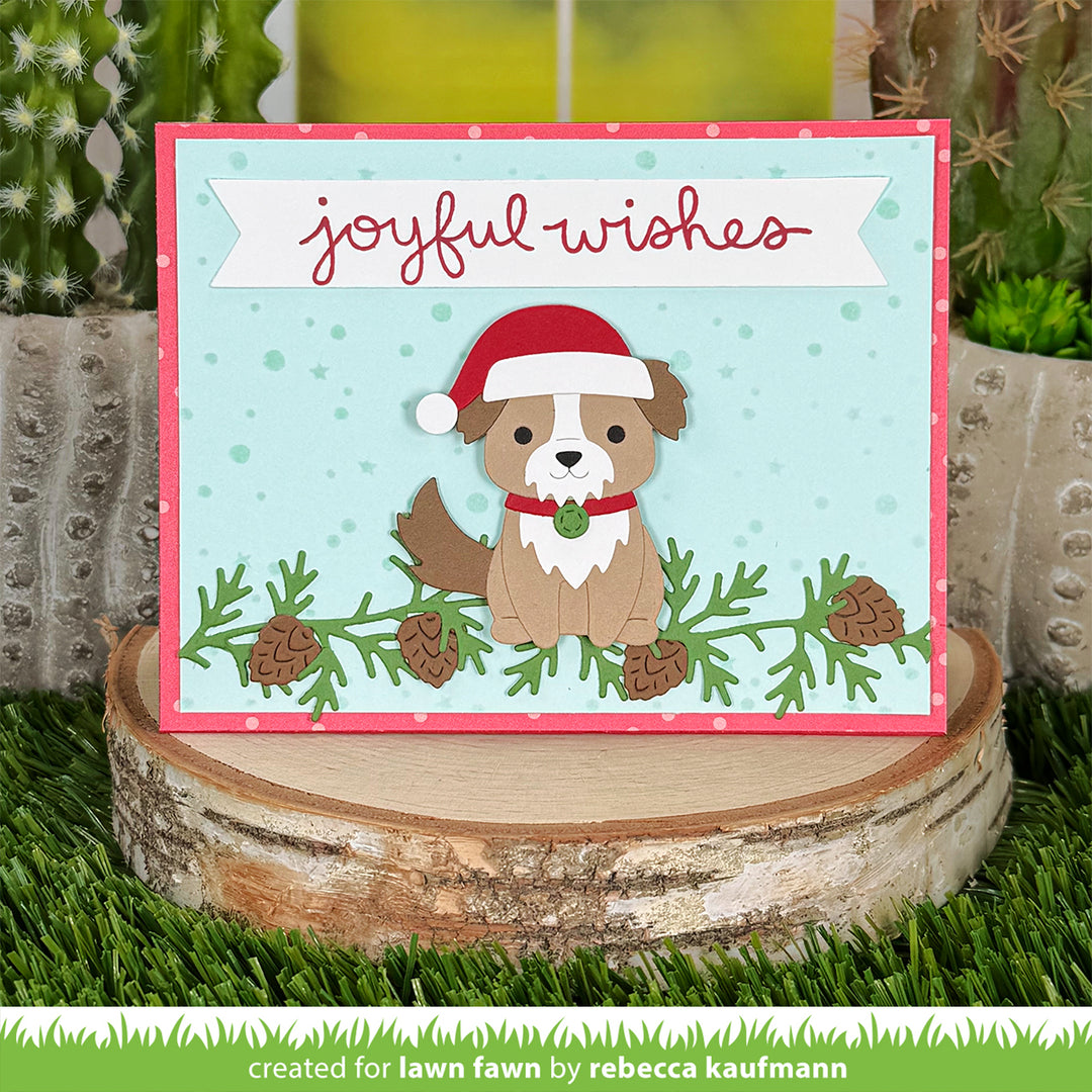 Lawn Fawn Build-A-Dog Joyful Wishes card with a puppy in a Santa hat among pine branches, by Rebecca Kaufmann