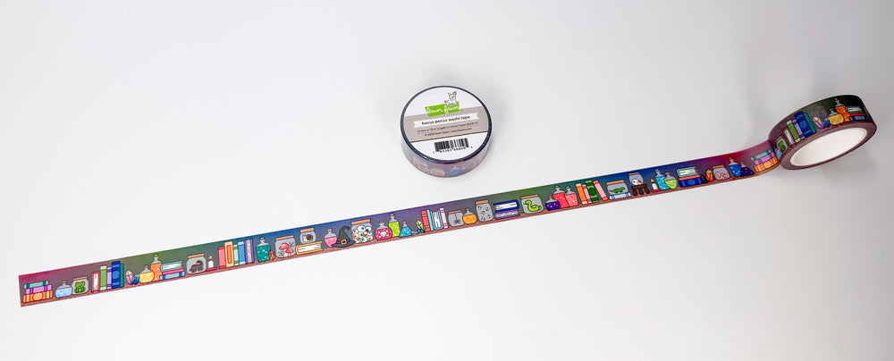 A roll of decorative washi tape with a colorful cartoon book and library illustration pattern, shown partially unrolled on a white background next to its spool.