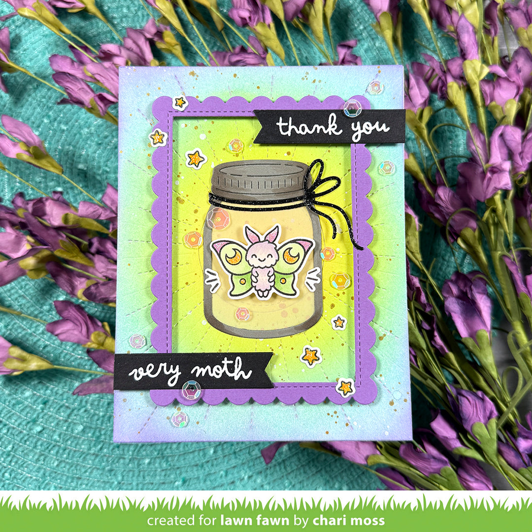 Card with a butterfly design inside a mason jar, surrounded by purple flowers on a textured surface.