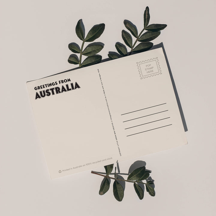 Postcard with 'Greetings from Australia' text and eucalyptus leaves on a light background