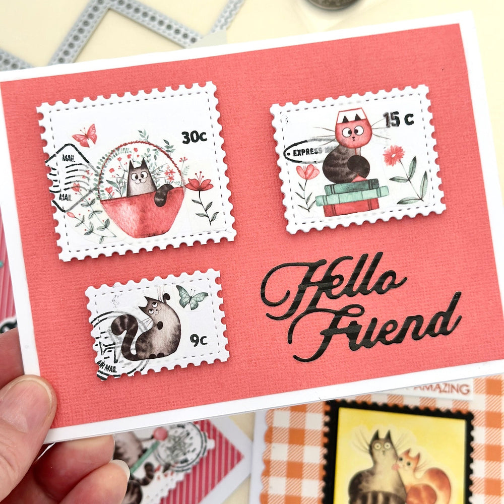 Card with postage collage stamp designs and 'Hello Friend' text, featuring chunky cat stickers and surrounded by more cards and stamps.