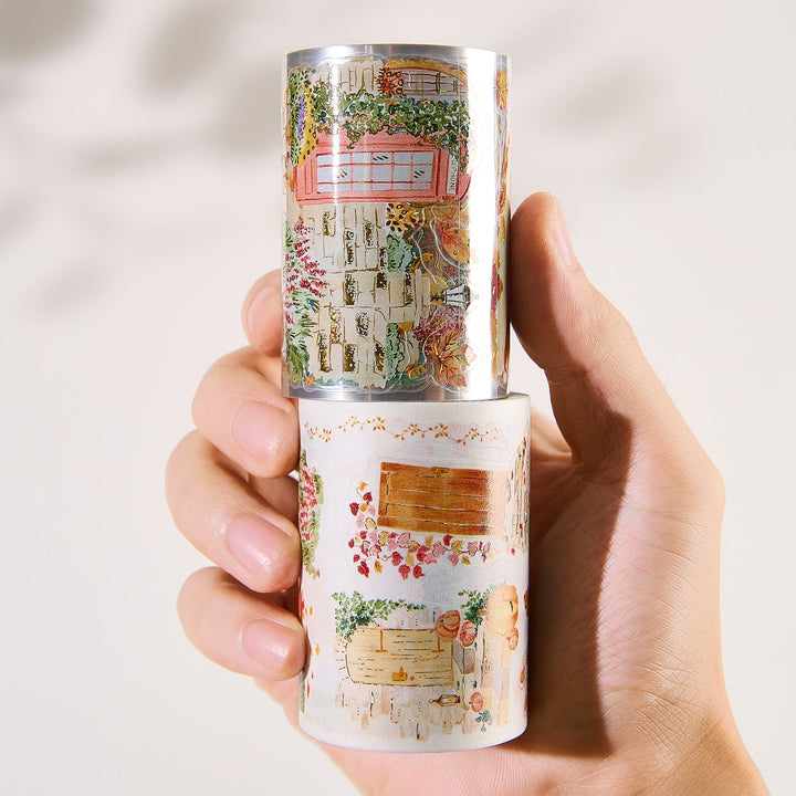 Hand holding the washi and PET rolls of The Washi Tape Shop Autumn Village Wide Washi/PET Tape
