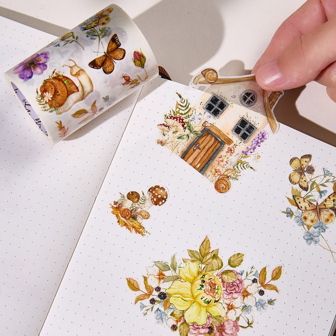 Hand peeling a pre-cut piece from The Washi Tape Shop Golden Harvest Wide Washi/PET Tape onto a journal page