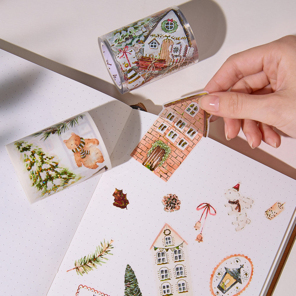 Hand peeling a pre-cut piece from The Washi Tape Shop Holiday Hamlet Wide Washi/PET Tape onto a journal page