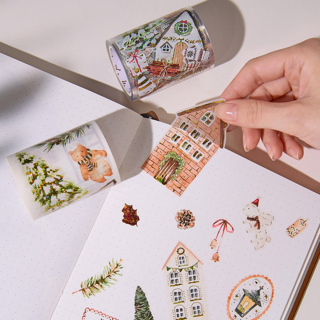 Hand peeling a pre-cut piece from The Washi Tape Shop Holiday Hamlet Wide Washi/PET Tape onto a journal page