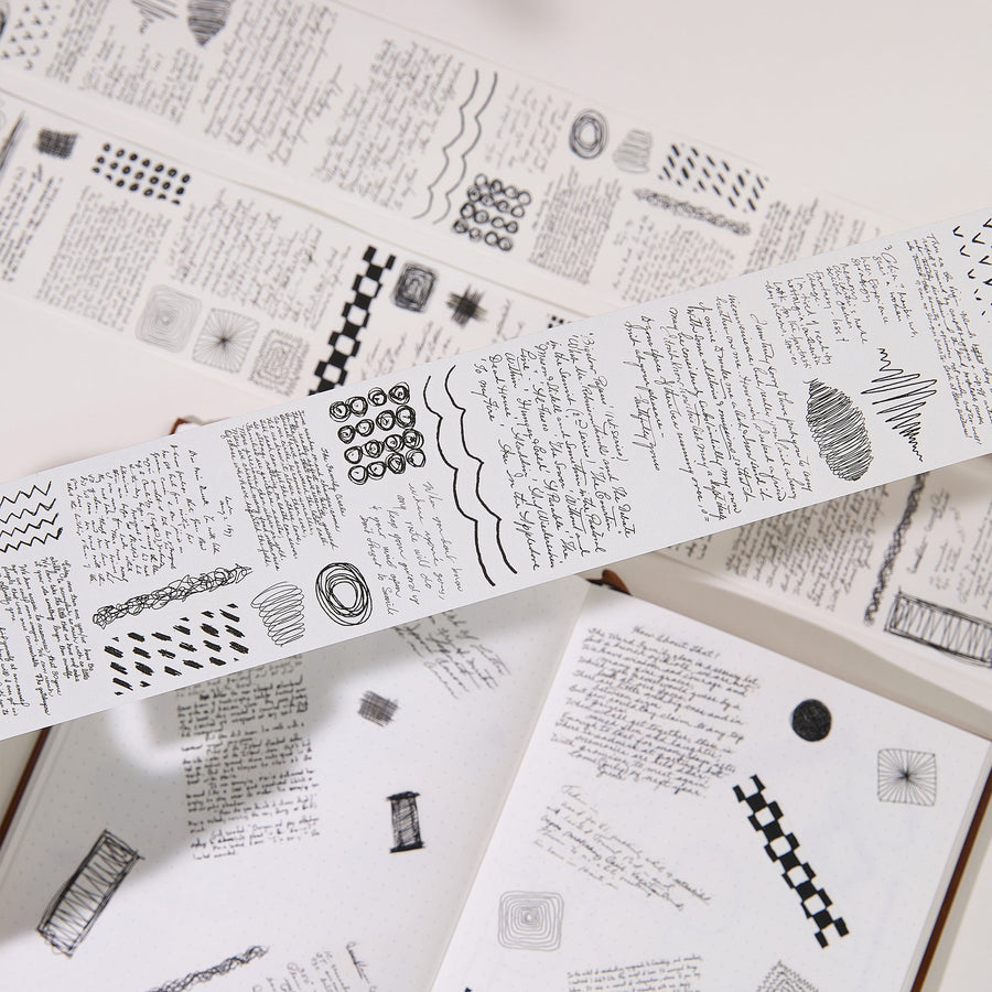Strips of The Washi Tape Shop Scribbled Thoughts Wide Washi/PET Tape laid flat with the rolls, showing the full design