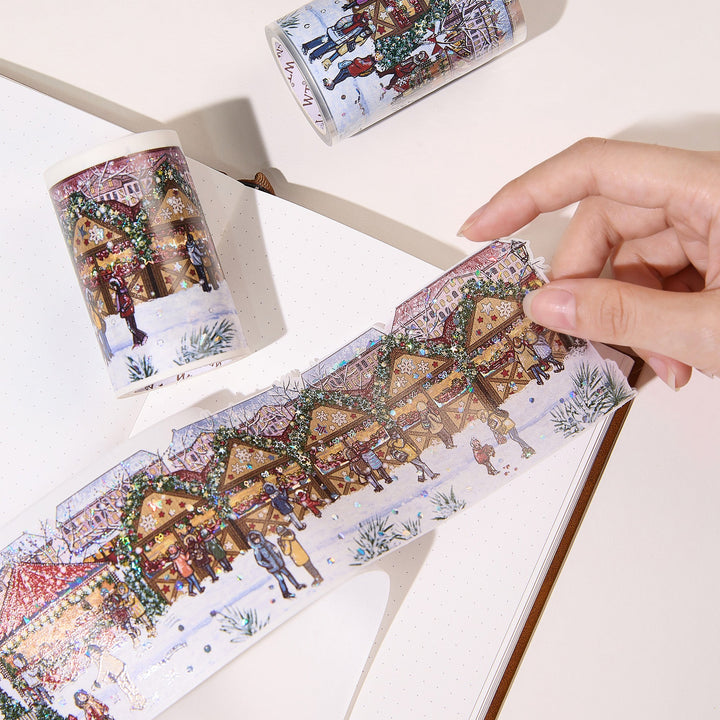 Hand peeling a pre-cut piece from The Washi Tape Shop Yuletide Glow Wide Washi/PET Tape onto a journal page