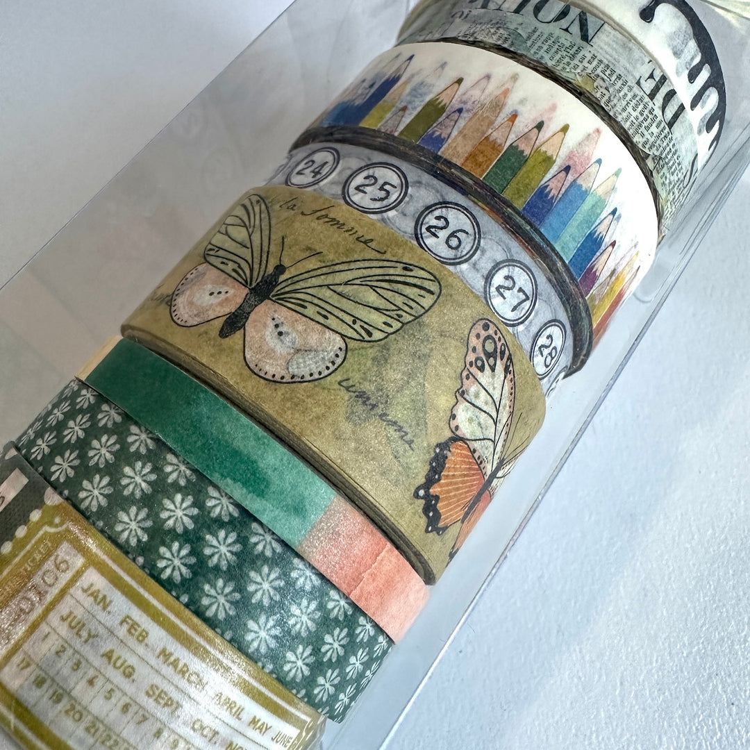 Decorative rolls of washi tape with butterfly designs and colourful patterns on a white surface.