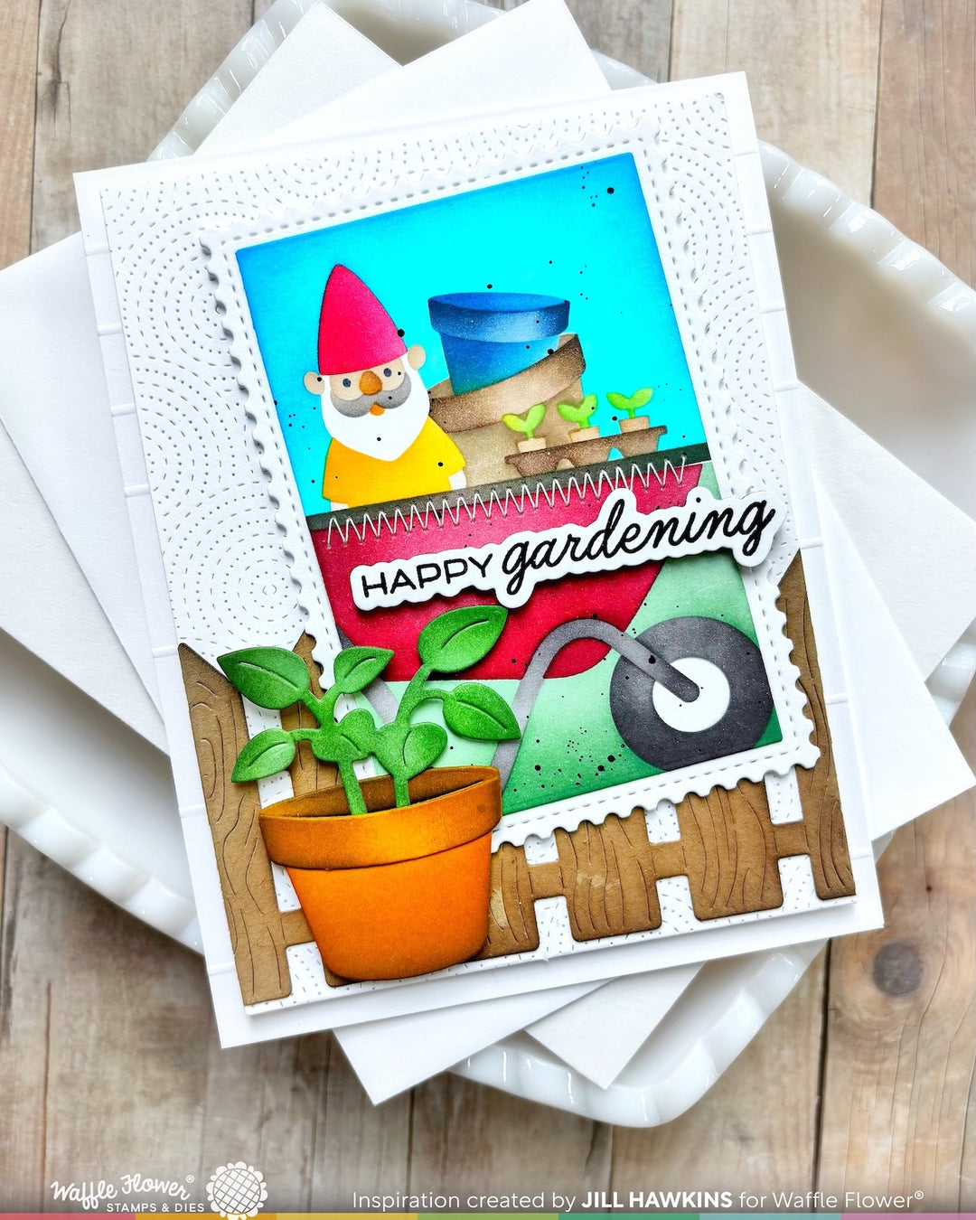 Greeting card with a gnome, plants, and 'Happy Gardening' text on a wooden surface.