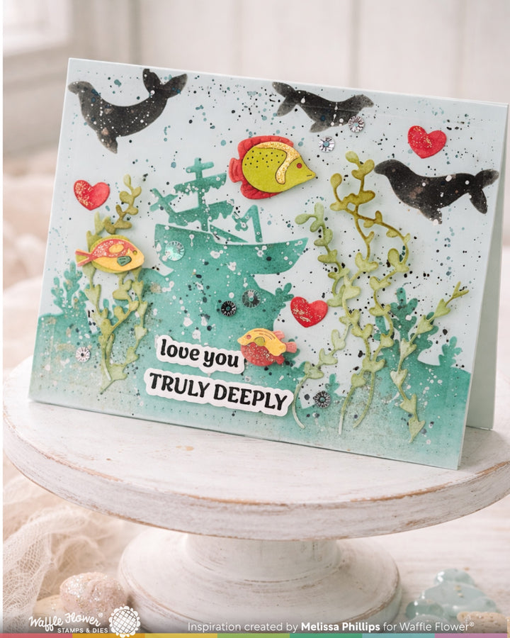 Card with underwater scene, fish, and coral with 'love you truly deeply' text on a white stand.