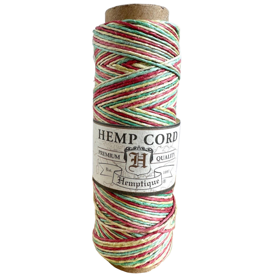Spool of hemp cord with a visible brand label on a wooden surface.