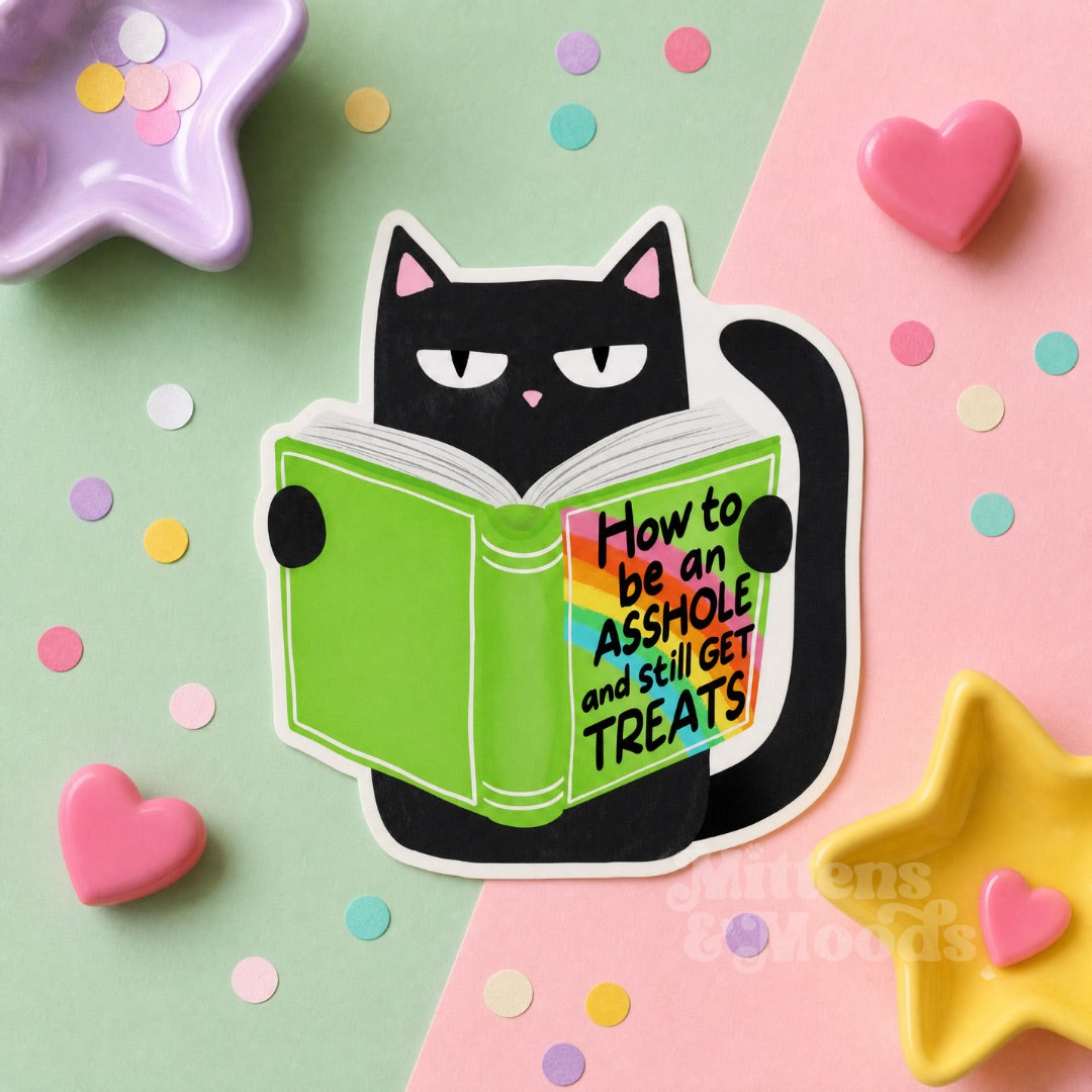 A die-cut sticker featuring a black cat reading a green book with the text 'How to be an ASSHOLE and still GET TREATS' on the cover, styled on a pastel pink and mint background with confetti and star-shaped dishes.